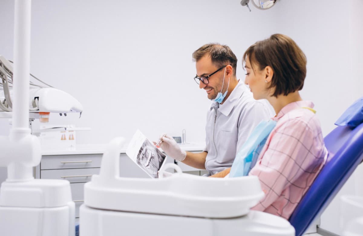 All-on-4 Bacău — medic stomatolog explică pacientei radiografia și planul de implant la Chromatic Dental Clinic