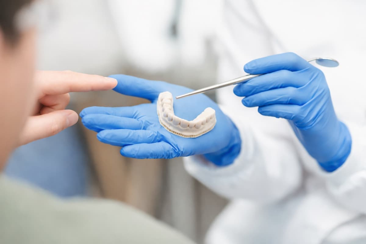Implant dentar după extracție Bacău — medic stomatolog explică pacientului modelul dentar și pașii pentru implant după extracția unui dinte la Chromatic Dental Clinic