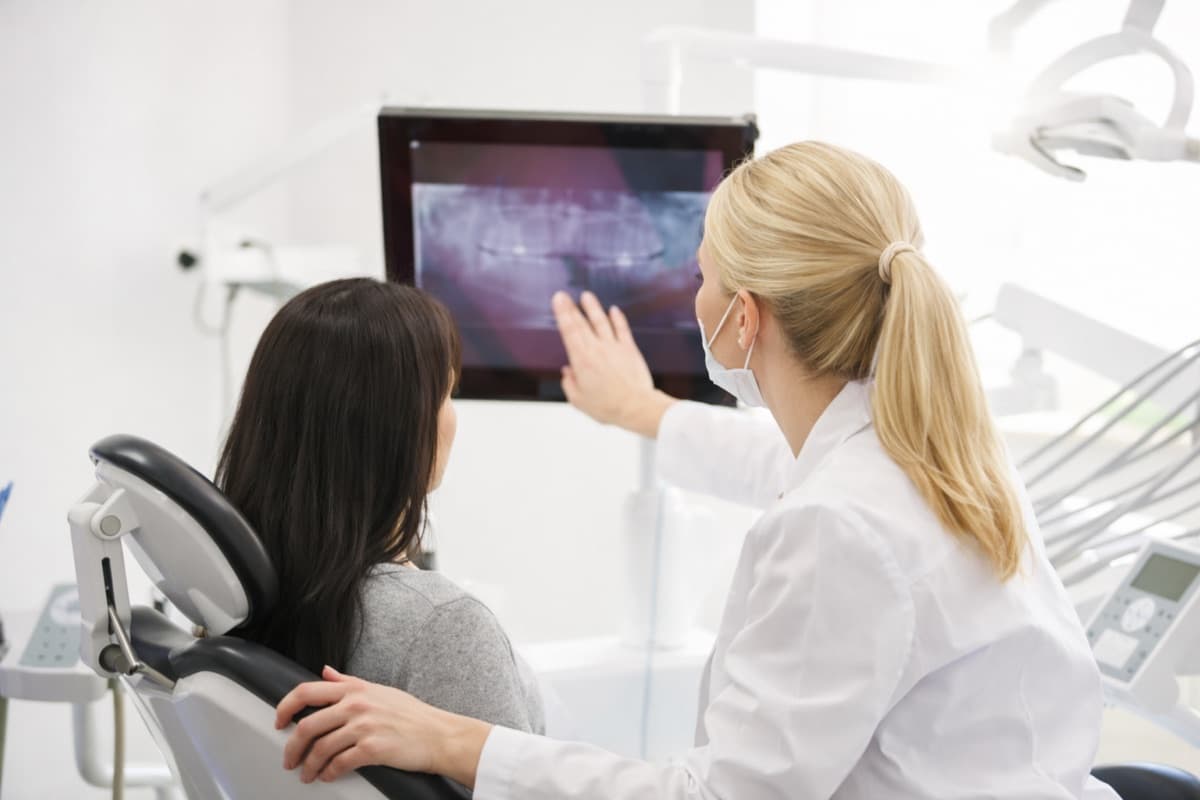 Implant întârziat după extracție Bacău — medic stomatolog analizează cu pacienta radiografia panoramică la 6 săptămâni după extracție pentru planificarea implantului la Chromatic Dental Clinic
