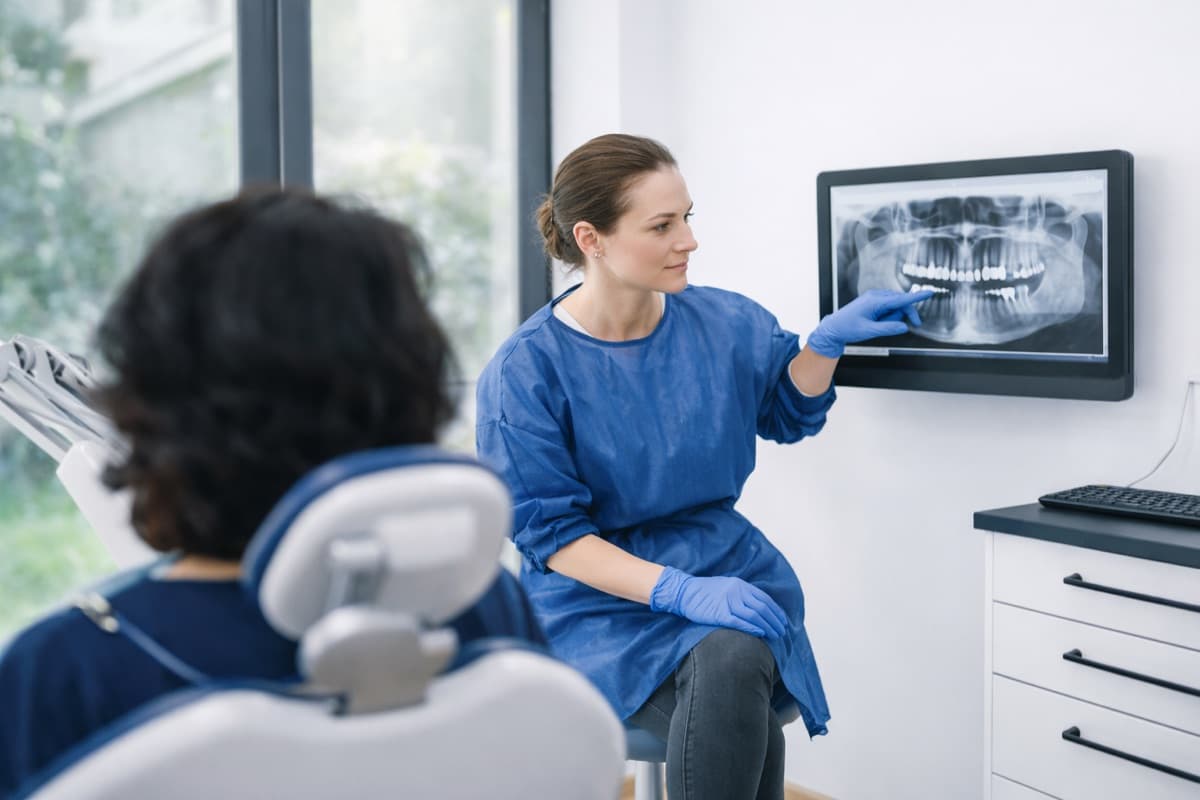 Medic stomatolog explică radiografia panoramică pacientei Bacău — discuție despre starea nervului dintelui și opțiunile de salvare a pulpei vitale prin coafaj pulpar la Chromatic Dental Clinic