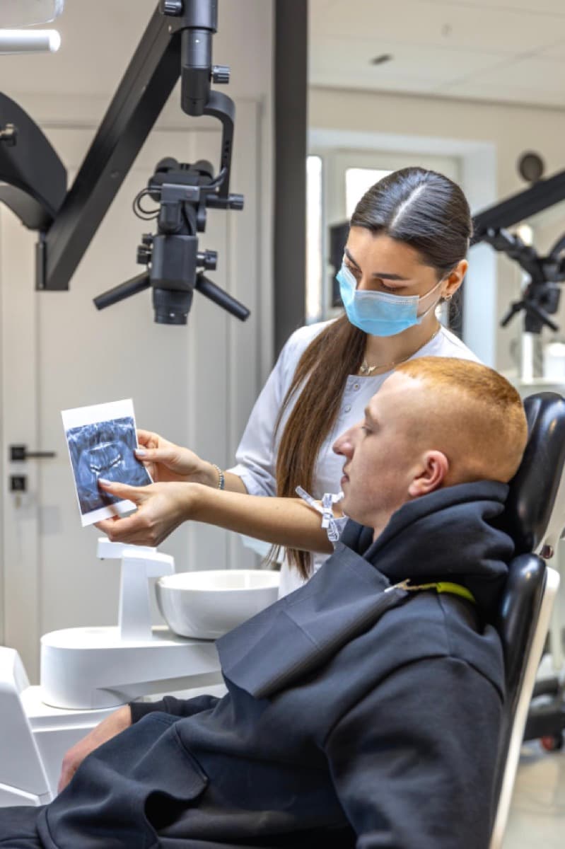 Microscop dentar Bacău — medic stomatolog explică pacientei radiografia înainte de tratamentul la microscop la Chromatic Dental Clinic