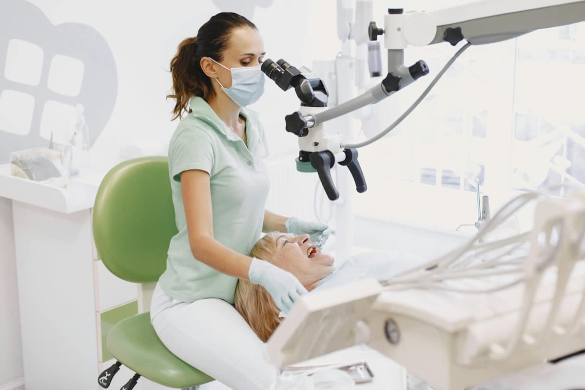 Tratament canal cu microscop Bacău — medic endodont lucrează sub microscopul dentar Zeiss la Chromatic Dental Clinic