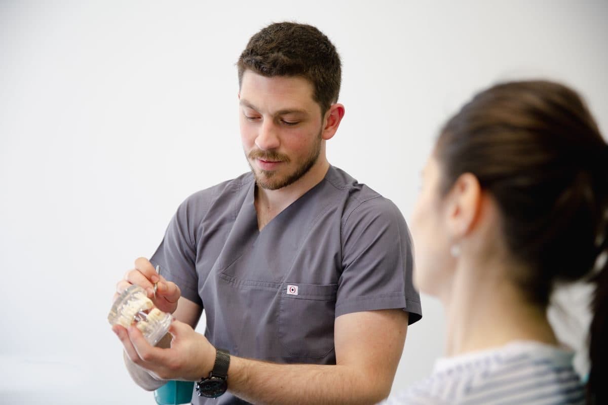 Consultație implant dentar Bacău: medicul explică pe un model cum se pune implantul, la Chromatic Dental Clinic