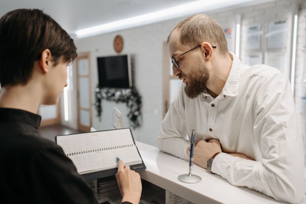 Implant dentar în rate în Bacău: pacient care discută la recepția clinicii Chromatic Dental variantele de plată
