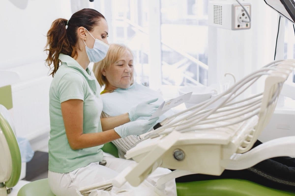 Periimplantită Bacău: medic stomatolog la controlul unei paciente cu implant dentar