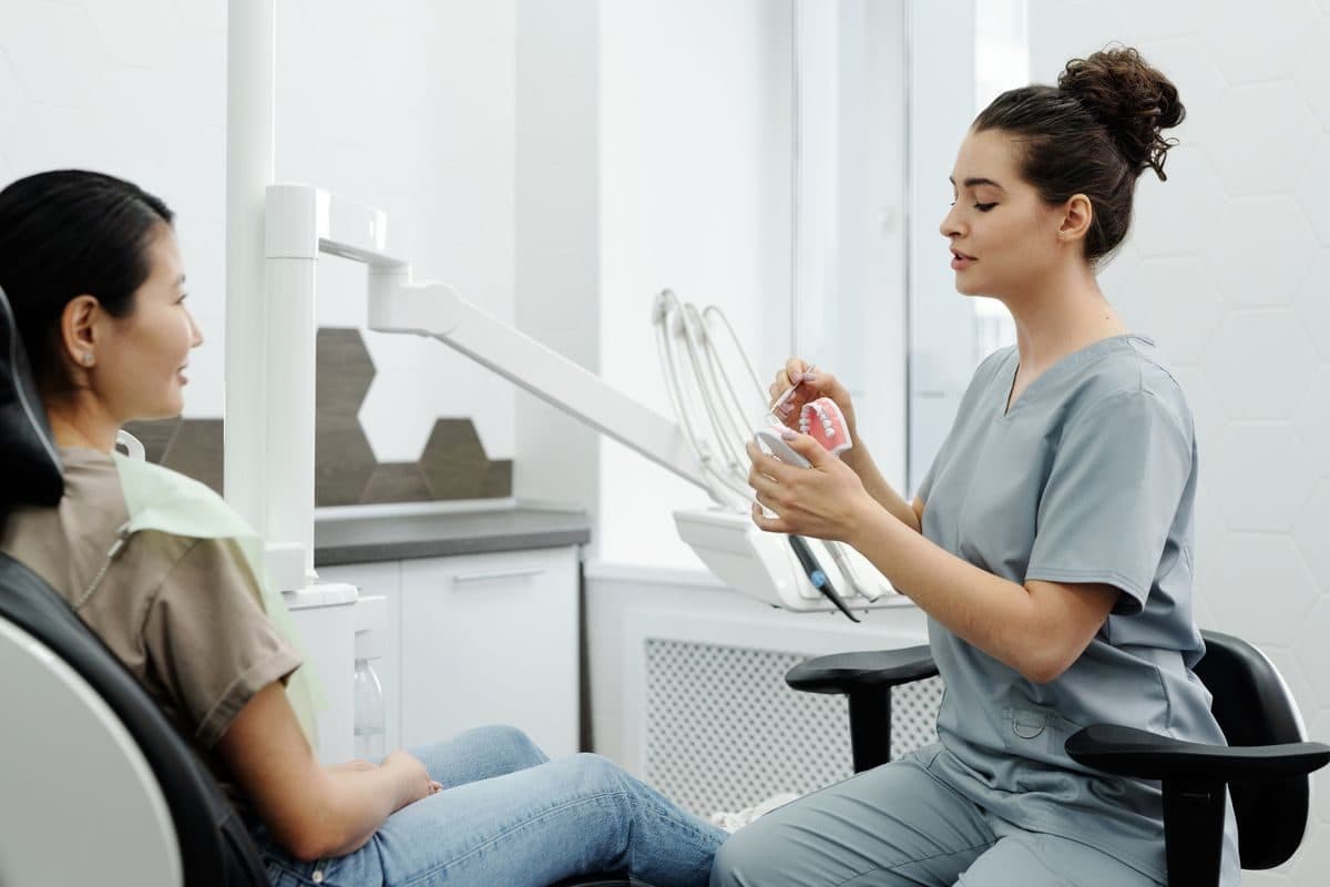 Pacientă în fotoliul stomatologic, la consultația pentru implant dentar în Bacău, în timp ce medicul pregătește planul de tratament